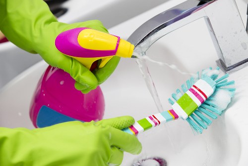 Technician cleaning trays and racks during oven cleaning
